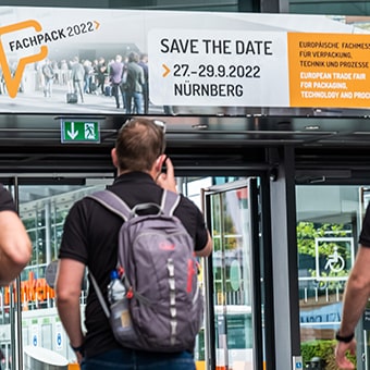 Zwei Männer mit dem Rücken zugewandt, mit Fachpack-Rucksäcken