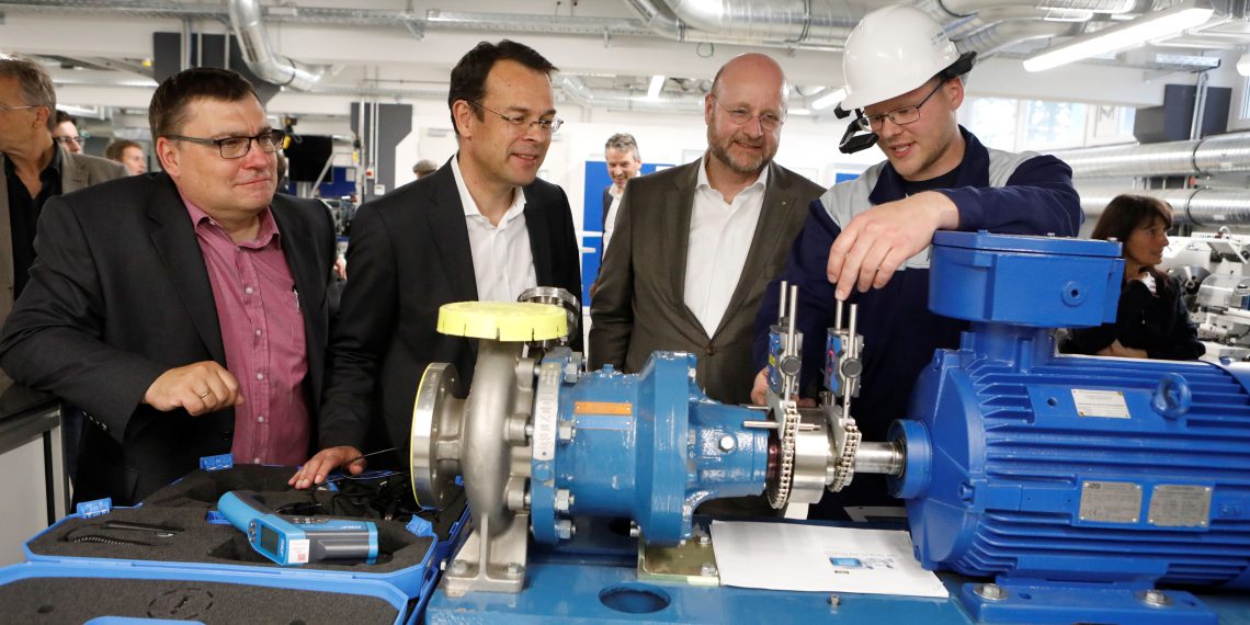 Stefan Pfitzner, Mitarbeiter der Infraserv Höchst Prozesstechnik GmbH, erläutert den Infraserv-Geschäftsführern Jürgen Vormann (Zweiter von rechts) und Dr. Joachim Kreysing (Zweiter von links) im Beisein von Frank Unger, Geschäftsführer Infraserv Höchst Prozesstechnik, an einem Pumpenaggregat, wie mithilfe der Lasertechnik die korrekte Ausrichtung erfolgt und wie Datenbrillen eingesetzt werden.